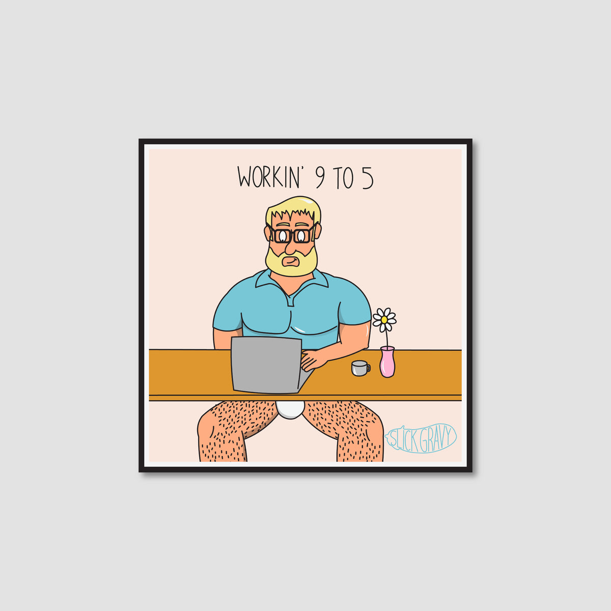 A framed art print with a white border on a light peach background. The print shows a cartoon man with blond hair and a beard sitting at a desk with a laptop, wearing only a blue shirt, with the text 'WORKIN' 9 TO 5' above him.